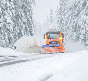 Winterdienstfahrzeug auf verschneiter Straße