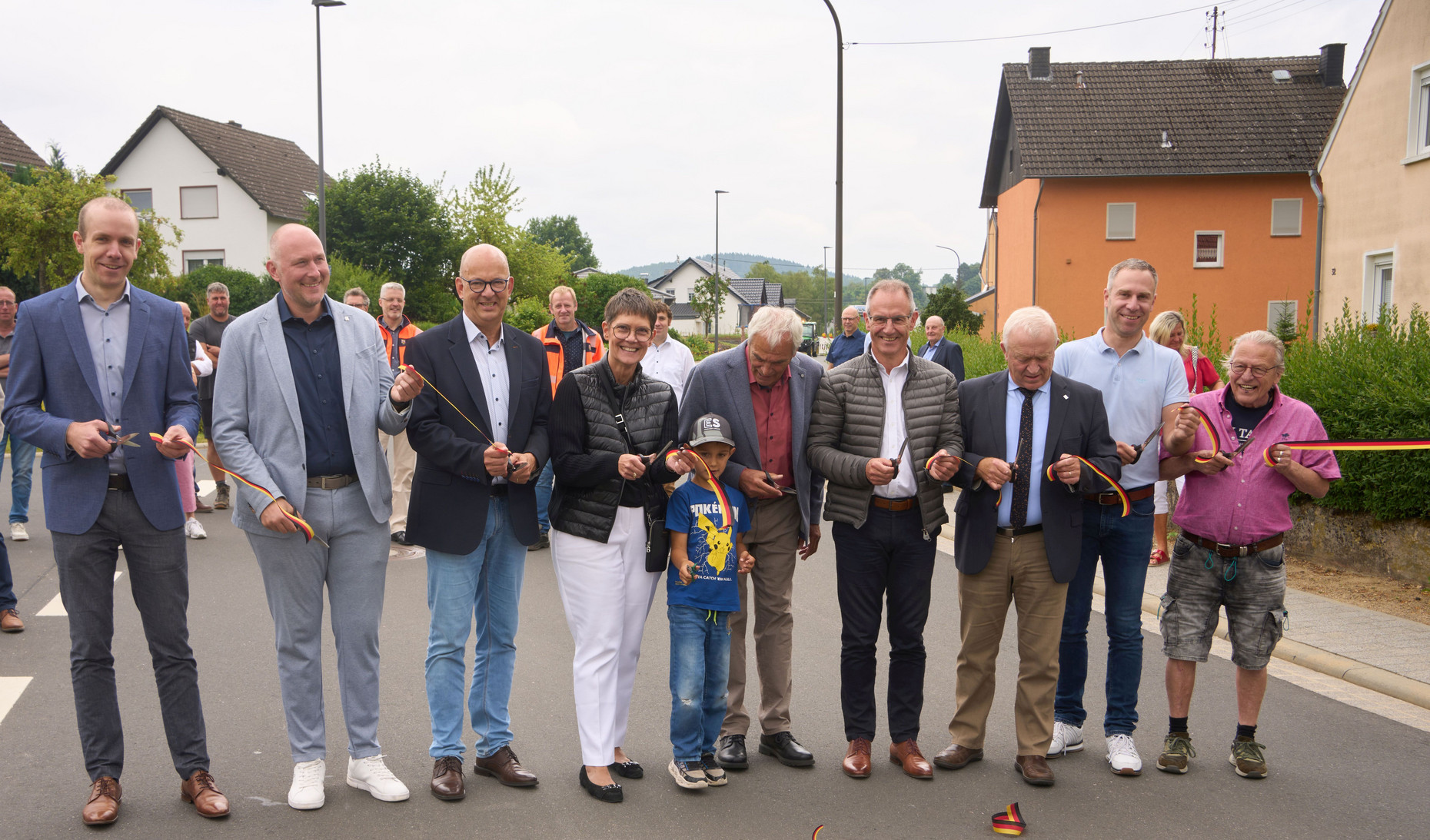 Verkehrsstaatssekretärin Petra Dick-Walter, LBM-Vertreter und Vertreter der Ortsgemeinde beim bandschnitt. Sie halten jeweils eine Schere sowie das Band in der Hand. 